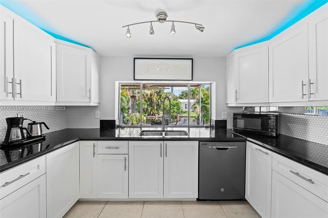 a kitchen with granite countertop white cabinets and white appliances