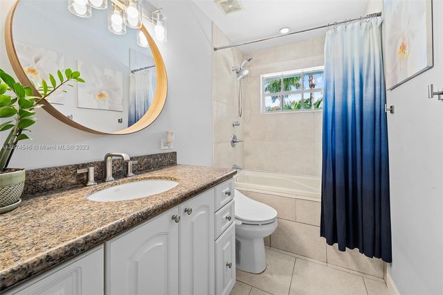 a bathroom with a granite countertop sink mirror toilet and bathtub