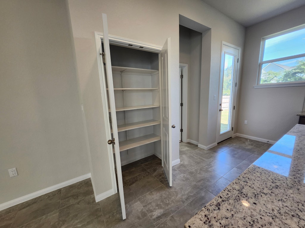 320 Creek Road, Unit 202 Dripping Springs, TX 78620 - Photo 19 of 26 a view of an empty room with wooden floor and windows