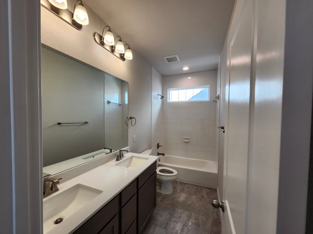 320 Creek Road, Unit 202 Dripping Springs, TX 78620 - Photo 22 of 26 a bathroom with a double vanity sink a toilet and shower