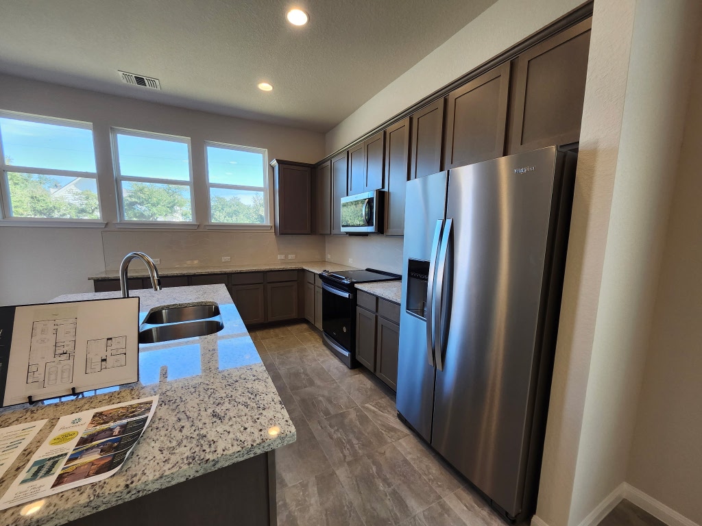 320 Creek Road, Unit 202 Dripping Springs, TX 78620 - Photo 7 of 26 a kitchen with granite countertop a refrigerator stove and sink