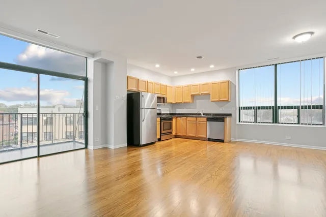 a view of large kitchen with a sink and refrigerator