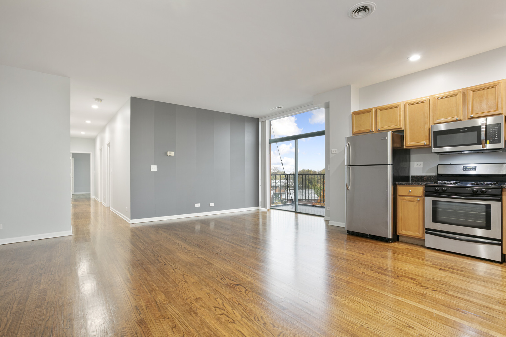 2451 West Howard Street, Unit 401 Chicago, IL 60645 - Photo 3 of 14 a view of a kitchen with a refrigerator a stove top oven a refrigerator and a wooden floor