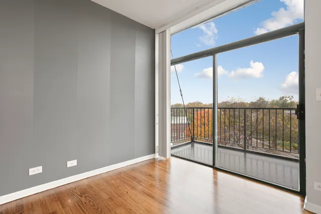 a view of empty room with wooden floor and fence