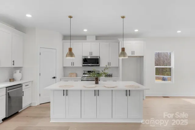 a kitchen with kitchen island white cabinets and refrigerator