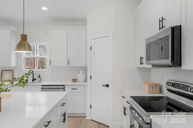 a kitchen that has a sink a stove and cabinets