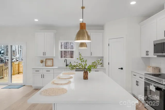 a dining room with stainless steel appliances kitchen island granite countertop a sink a stove a dining table and chairs