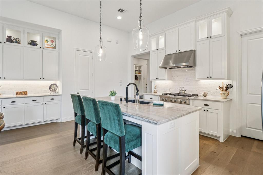 8277 Halifax The Colony, TX 75056 - Photo 11 of 37 a kitchen with stainless steel appliances granite countertop a sink a stove a refrigerator and white cabinets with wooden floor