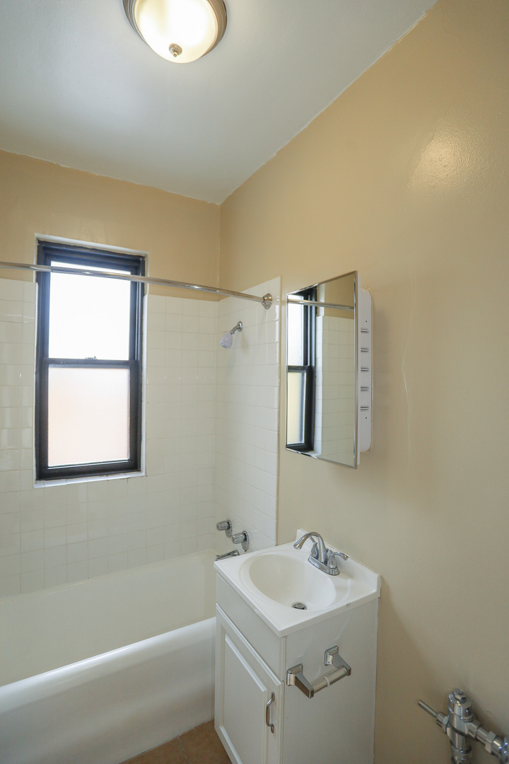 5326 South Cornell Avenue, Unit 511 Chicago, IL 60615 - Photo 6 of 10 a bathroom with a sink toilet vanity and tub