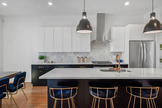 a kitchen with stainless steel appliances a dining table and chairs