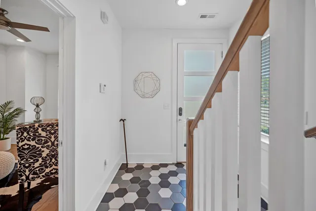 a view of a hallway with wooden floor and staircase