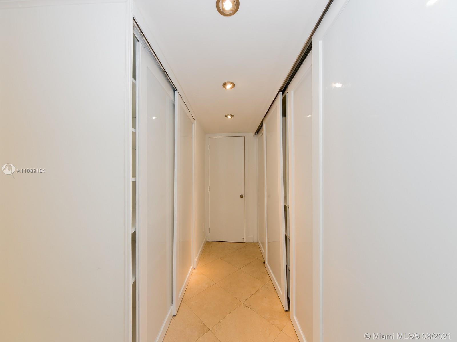 605 Ocean Drive, Unit 2L Key Biscayne, FL 33149 - Photo 11 of 18 a view of a hallway with wooden floor and staircase