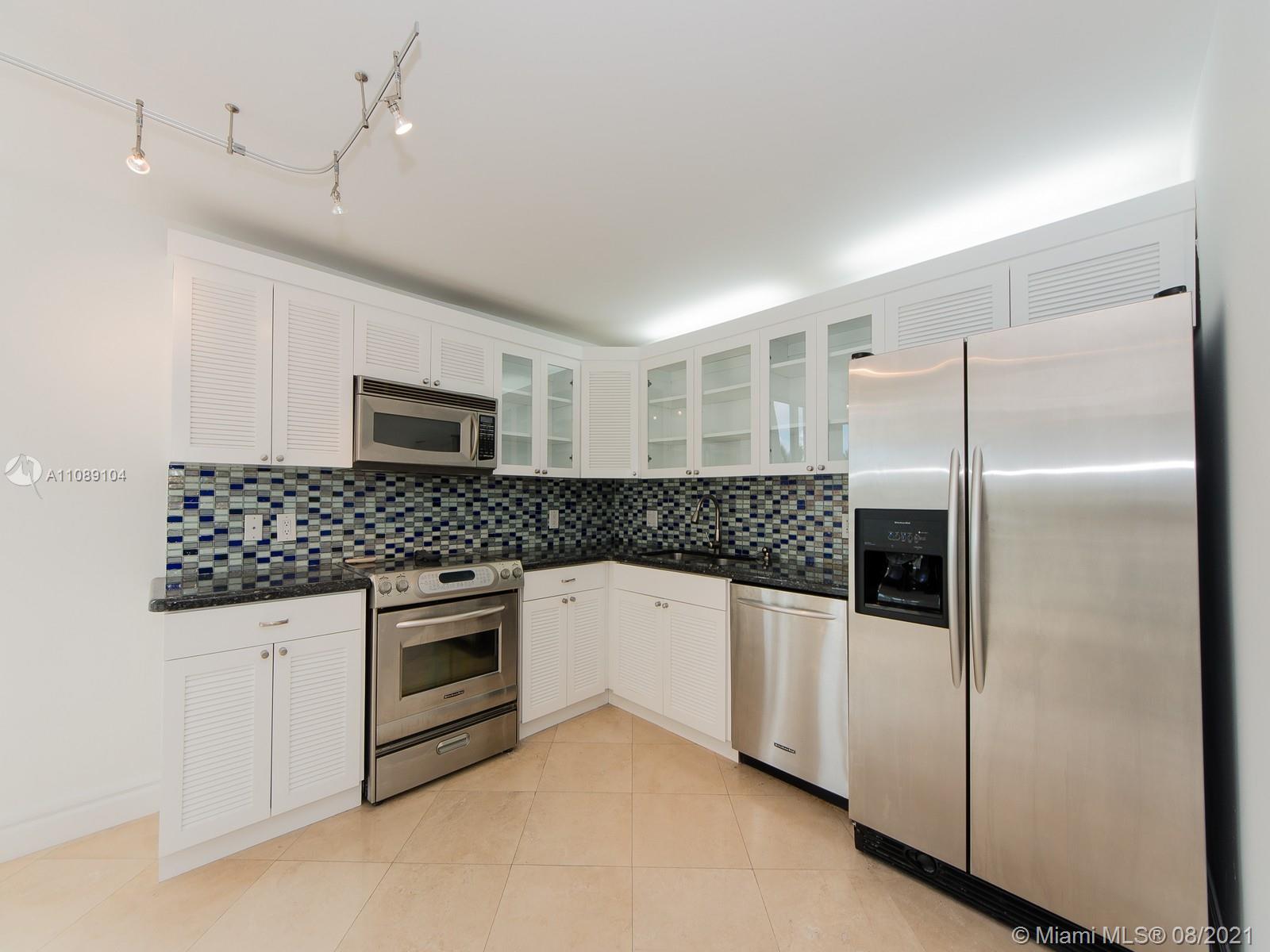 605 Ocean Drive, Unit 2L Key Biscayne, FL 33149 - Photo 4 of 18 a kitchen with stainless steel appliances granite countertop a refrigerator and a sink