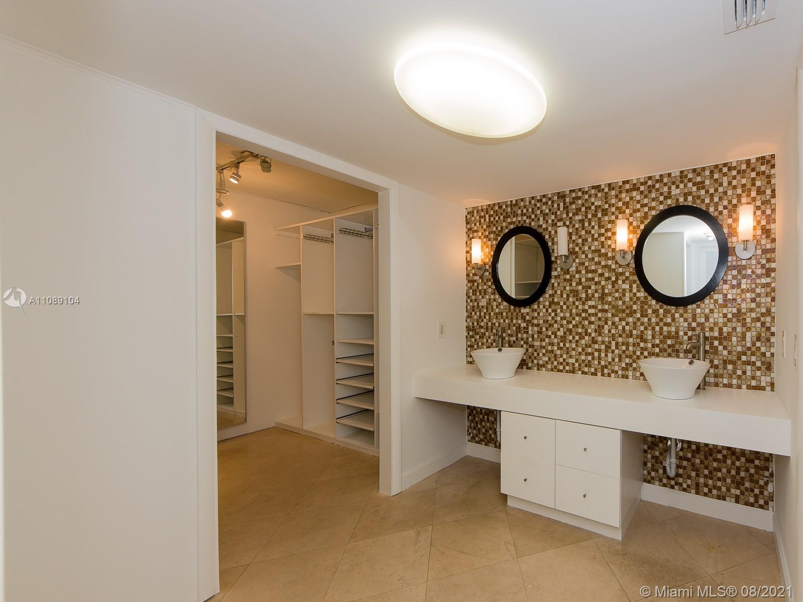 605 Ocean Drive, Unit 2L Key Biscayne, FL 33149 - Photo 9 of 18 wooden floor with a sink and a mirror