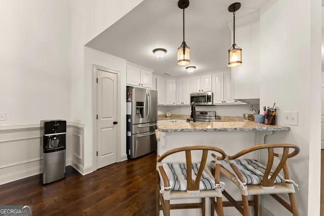 a kitchen with granite countertop a refrigerator and a sink