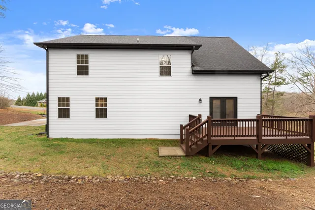 a view of a house with a wooden deck and a yard