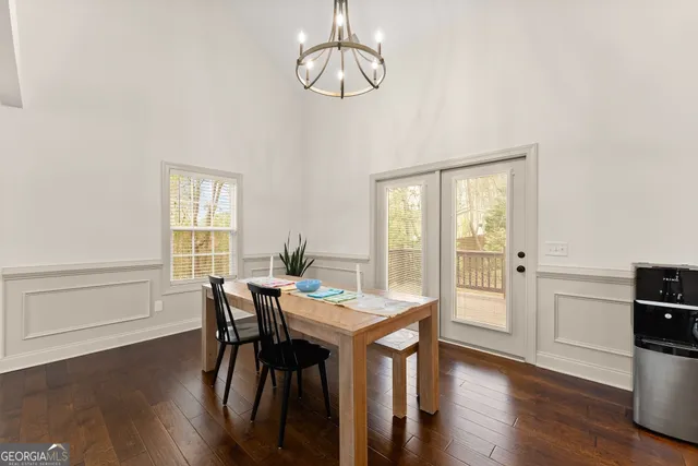 a view of a dining room with furniture a chandelier and wooden floor