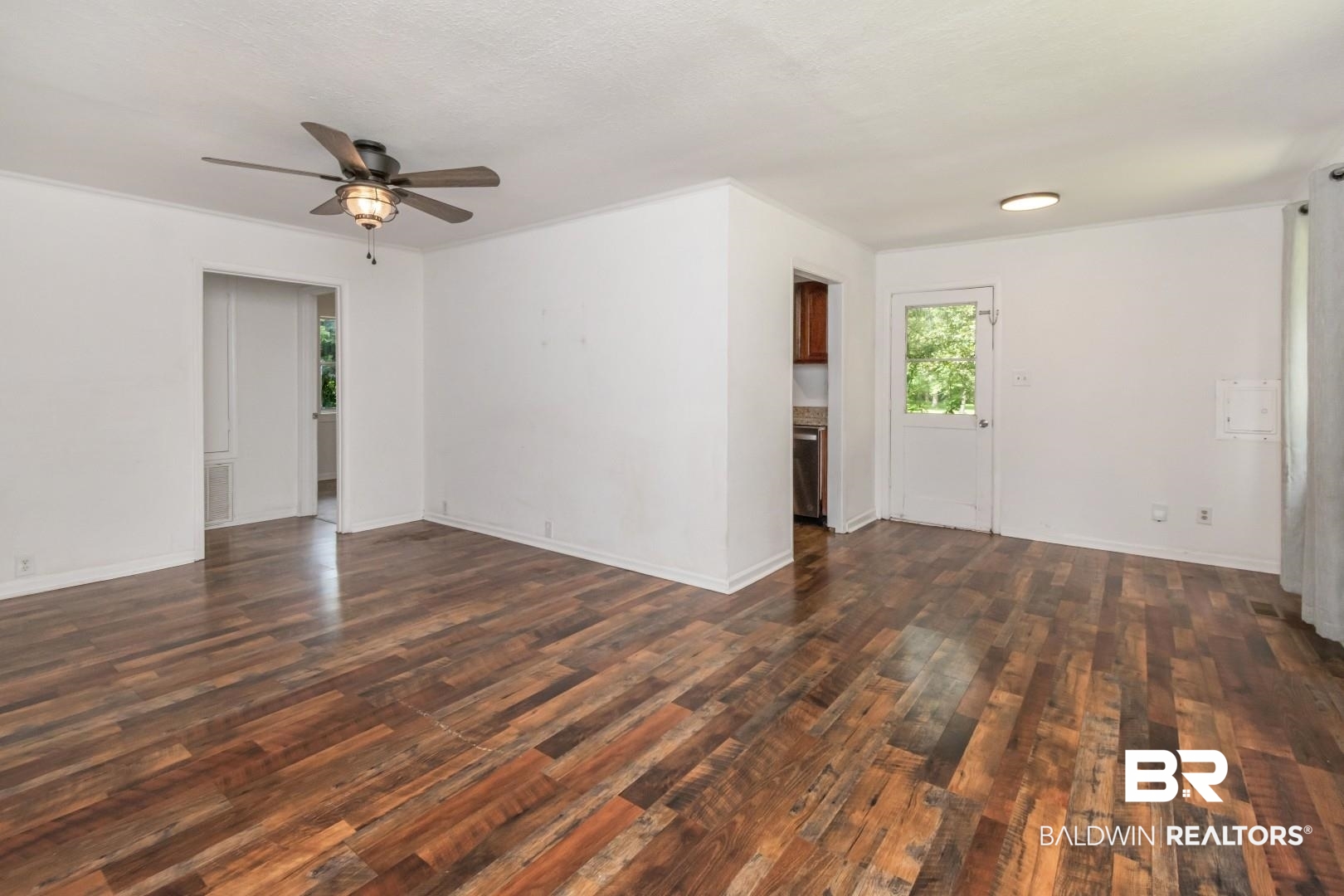 2905A McFarland Road, Unit F Mobile, AL 36695 - Photo 4 of 29 Spacious living area featuring wood-finish flooring, white walls, and a ceiling fan with integrated lighting