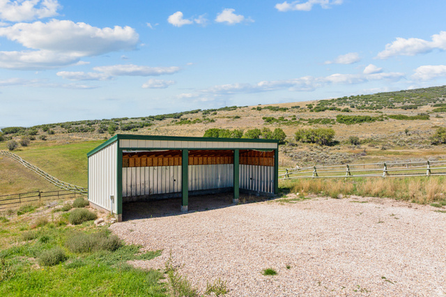 6117 North Rocky Ridge Road Peoa, UT 84061 - Photo 78 of 82 Open-air shelter with a metal roof and siding, supported by green structural beams