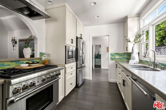 a kitchen with stainless steel appliances granite countertop a stove and a refrigerator