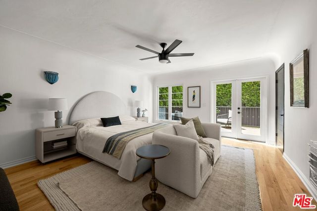 a bedroom with a large bed couch and a large window