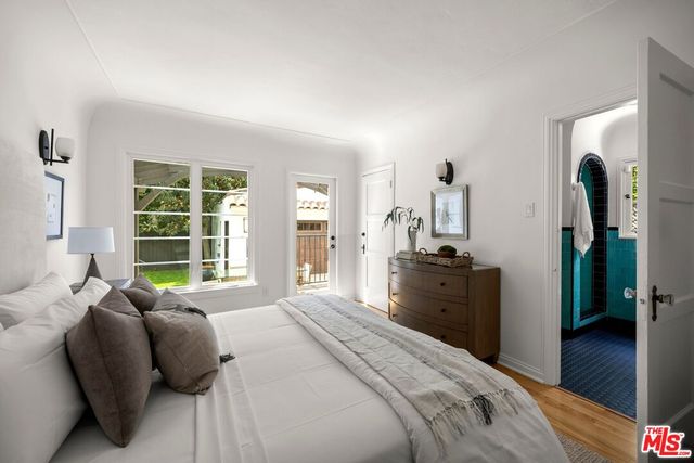 a bedroom with a bed and large windows