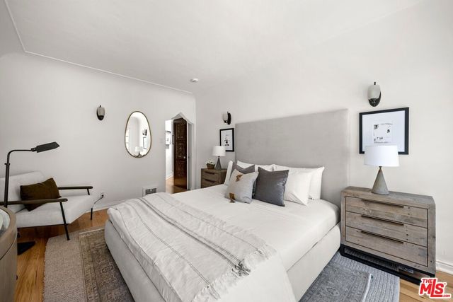 a bedroom with a bed and a lamp on dresser