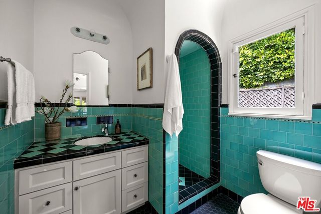 a bathroom with a toilet sink and mirror