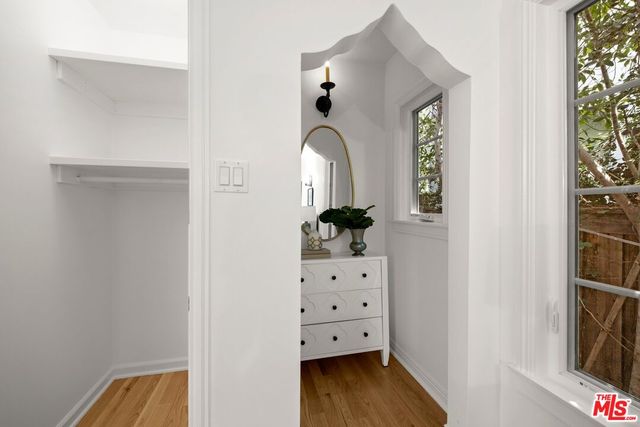 a view of walk in closet with wooden floor