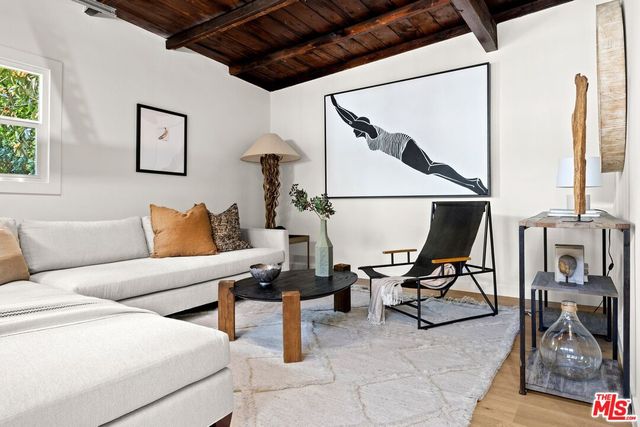 a living room with furniture and a painting on the wall