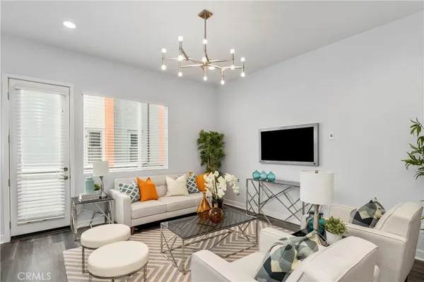 a living room with furniture a flat screen tv and a window