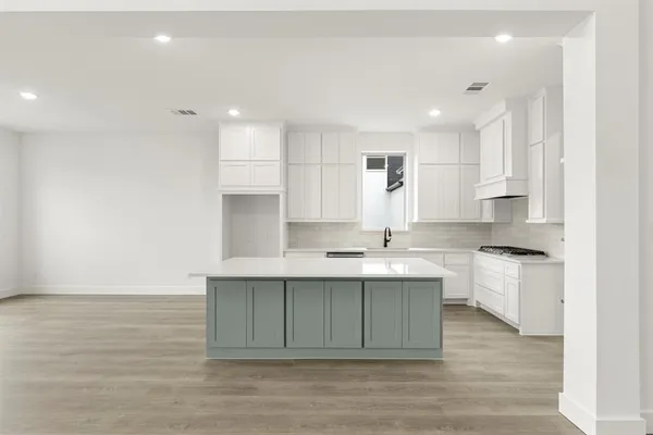 a large kitchen with kitchen island a sink stainless steel appliances and cabinets