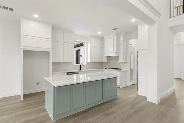 a kitchen with kitchen island a sink appliances and cabinets