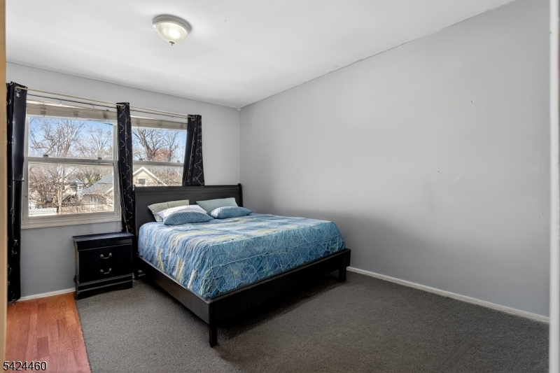 216 New Street, Unit A Orange, NJ 07050 - Photo 11 of 17 a bedroom with a bed lamp and window