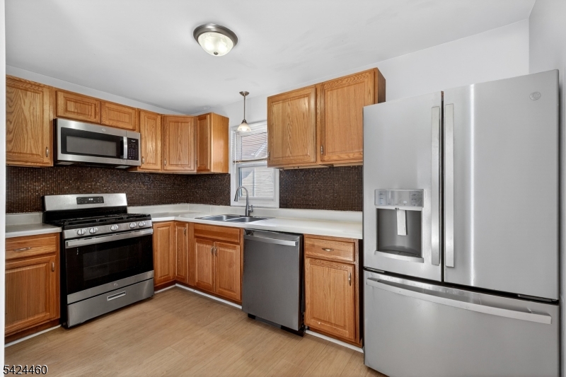 216 New Street, Unit A Orange, NJ 07050 - Photo 2 of 17 a kitchen with stainless steel appliances granite countertop a refrigerator stove microwave and sink