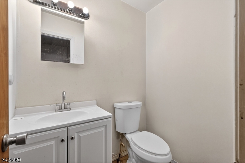 216 New Street, Unit A Orange, NJ 07050 - Photo 4 of 17 a bathroom with a toilet a sink and mirror