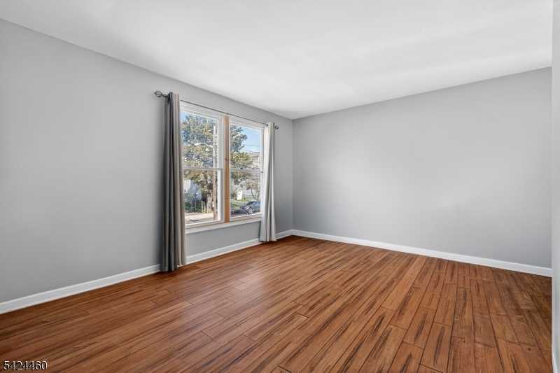 216 New Street, Unit A Orange, NJ 07050 - Photo 5 of 17 a view of an empty room with wooden floor and a window
