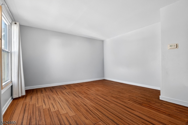 216 New Street, Unit A Orange, NJ 07050 - Photo 6 of 17 a view of an empty room with wooden floor and a window
