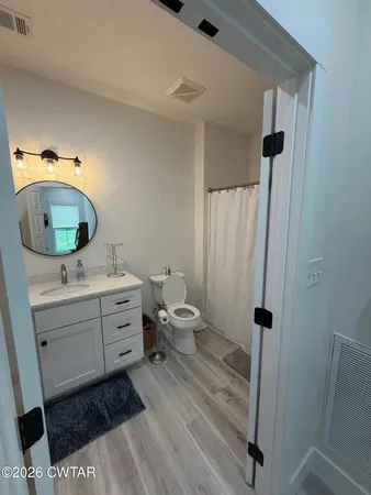 a bathroom with a sink mirror vanity and toilet