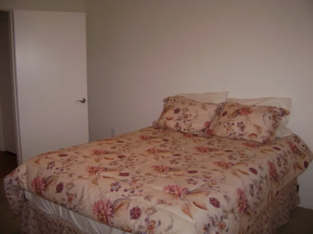 a large bed sitting in a bedroom next to a window