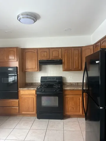 a kitchen with granite countertop a refrigerator and a stove