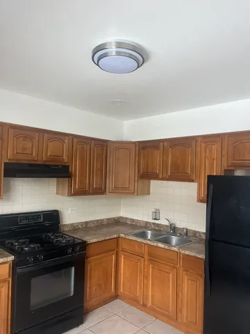a kitchen with granite countertop a refrigerator stove and sink