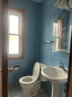 a bathroom with a sink a toilet and a window