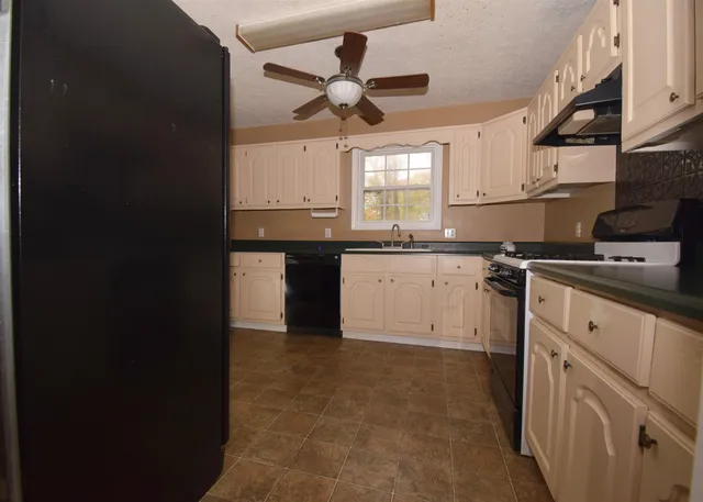 a kitchen with granite countertop a sink stainless steel appliances and cabinets