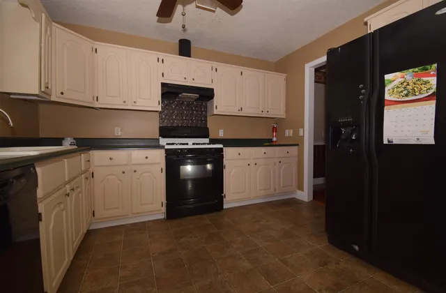 a kitchen with white cabinets and appliances
