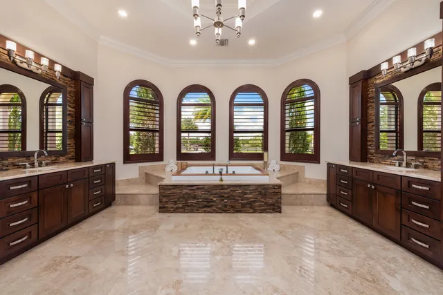 a large spacious bathroom with a granite countertop tub a double vanity sink and a large mirror