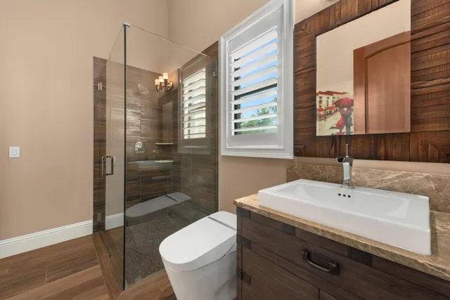 a bathroom with a sink a toilet and shower