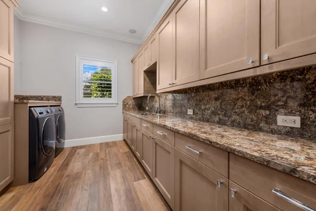a kitchen with granite countertop a sink a washer and dryer