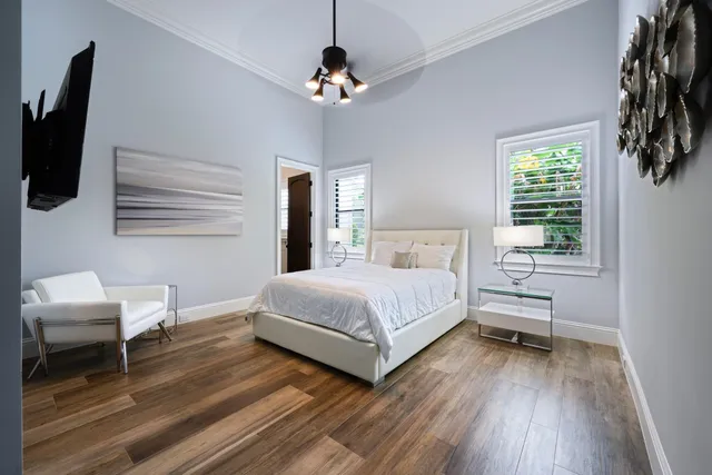 a bedroom with a bed a flat screen tv and a window