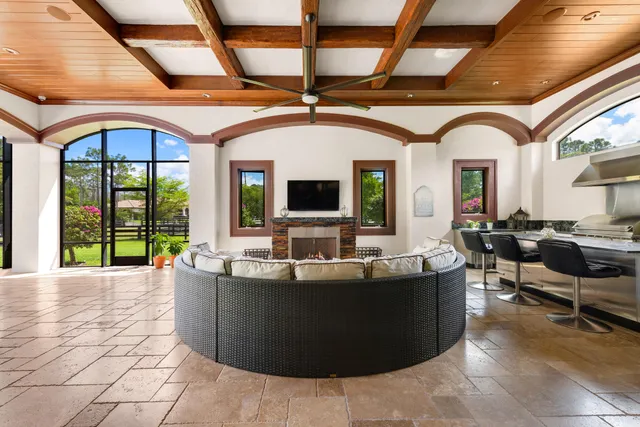 a living room with couches a dining table and chairs with outer view